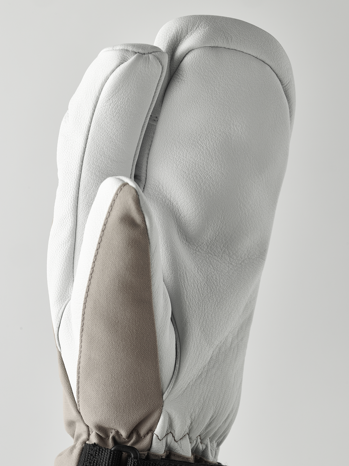 3-finger ski gloves in white/cream leather with mitten-style finger shape.