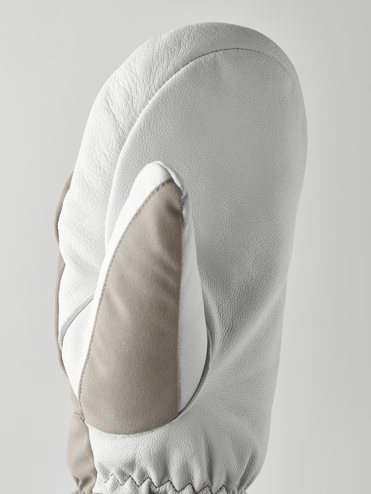 White ski mitten with textured palm and curved finger shell