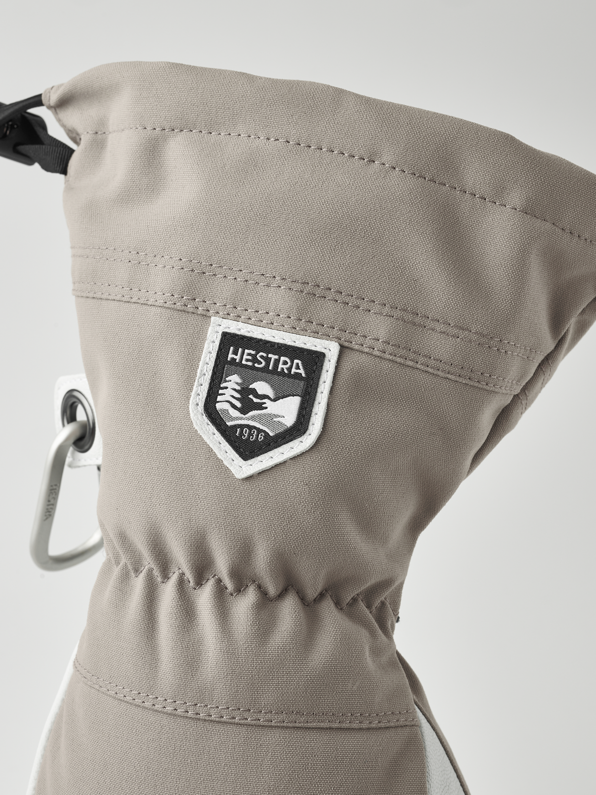 Light tan ski glove with HESTRA shield patch and metal carabiner loop