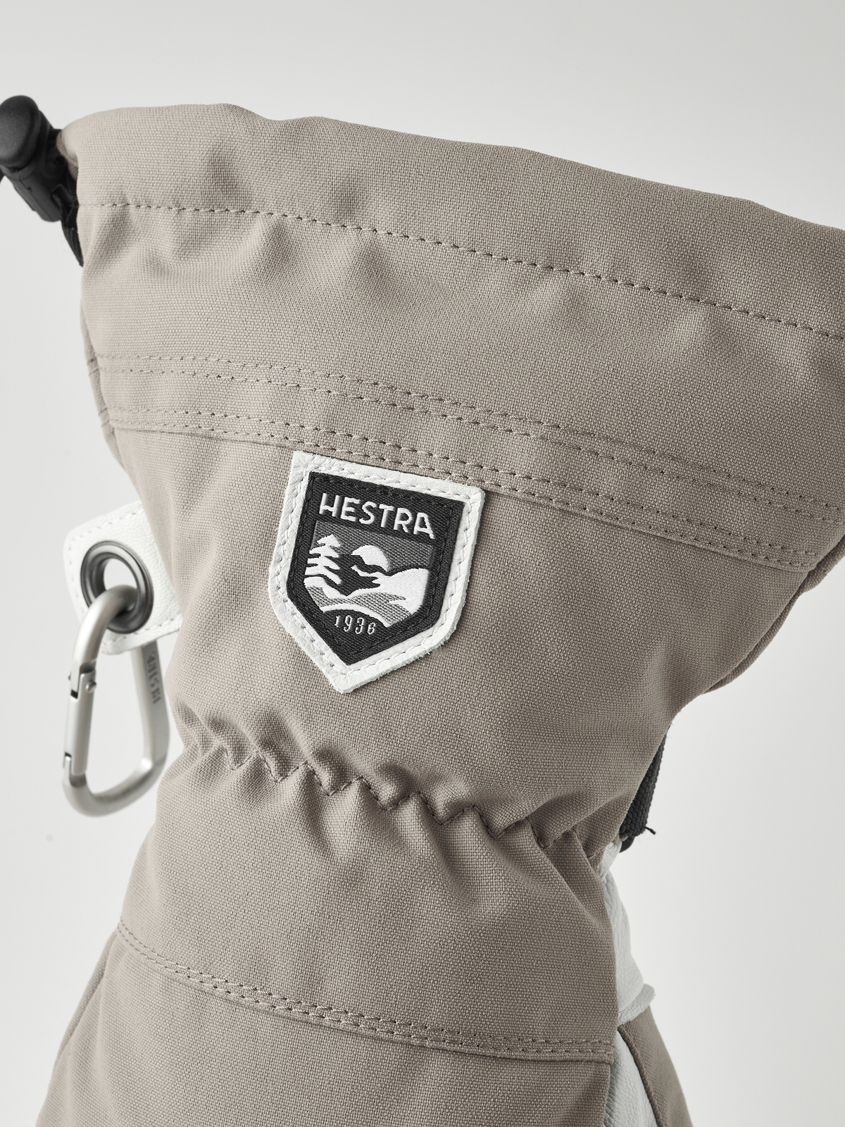 Beige ski mitten cuff with HESTRA logo patch and metal carabiner ring