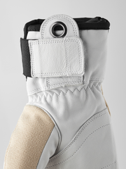 White 3-finger leather glove cuff close-up with metal ring and elastic top