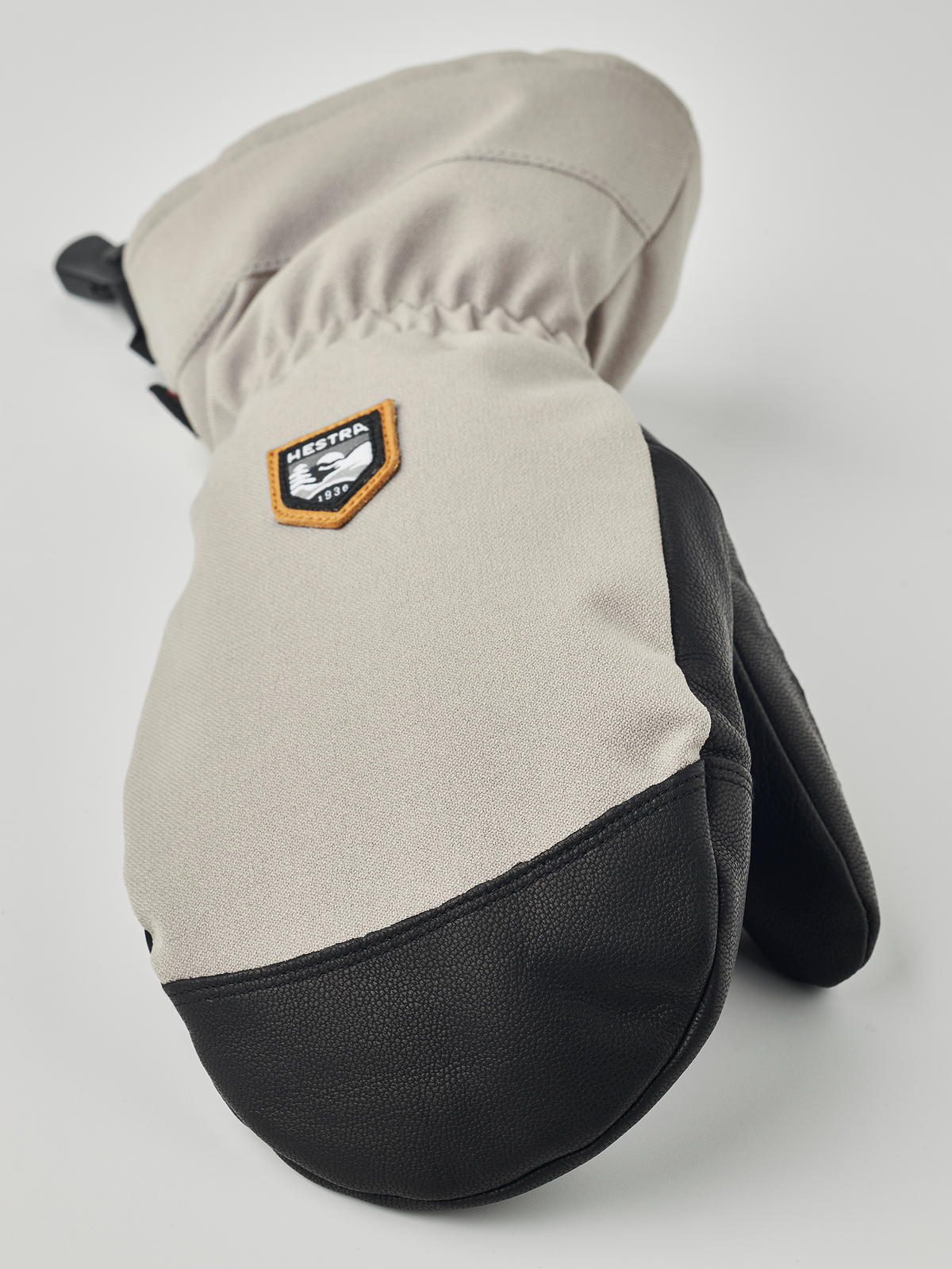 Beige and black mountain mittens with HESTRA patch and wrist strap