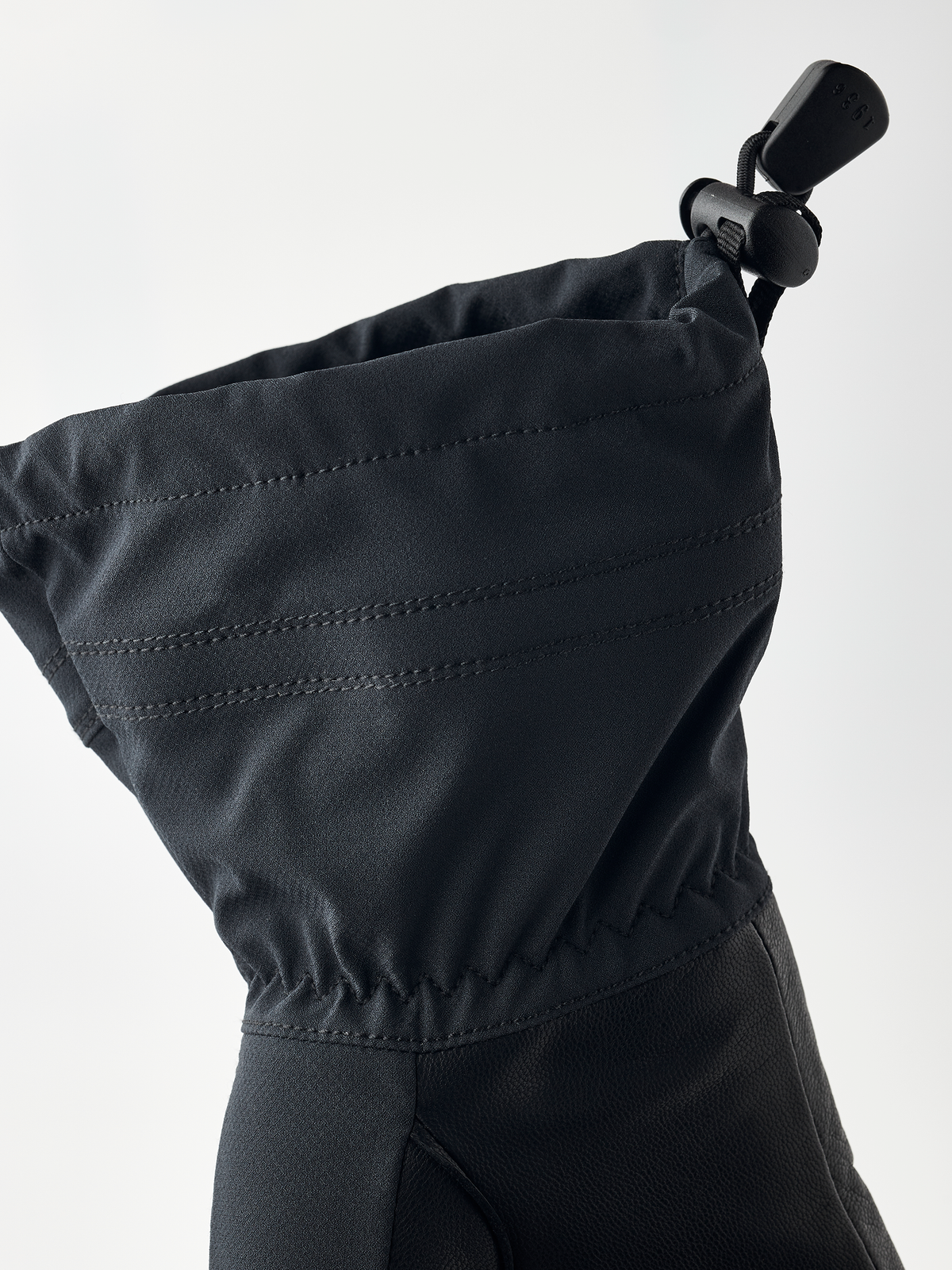 Black junior gloves with drawstring cuff, stitched seams, and HESTRA patch