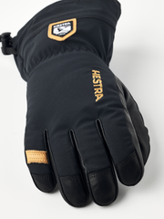 Black junior ski gloves with HESTRA lettering on back and leather finger panels