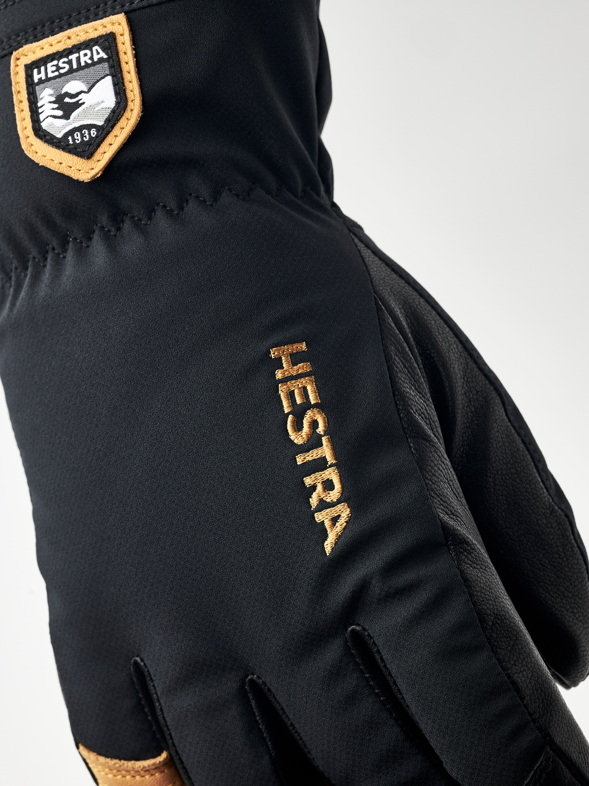 Black junior gloves with HESTRA embroidery on back and leather fingertips