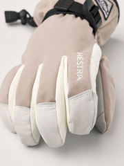 Close-up beige powder gauntlet gloves with white leather palms and logo embroidery