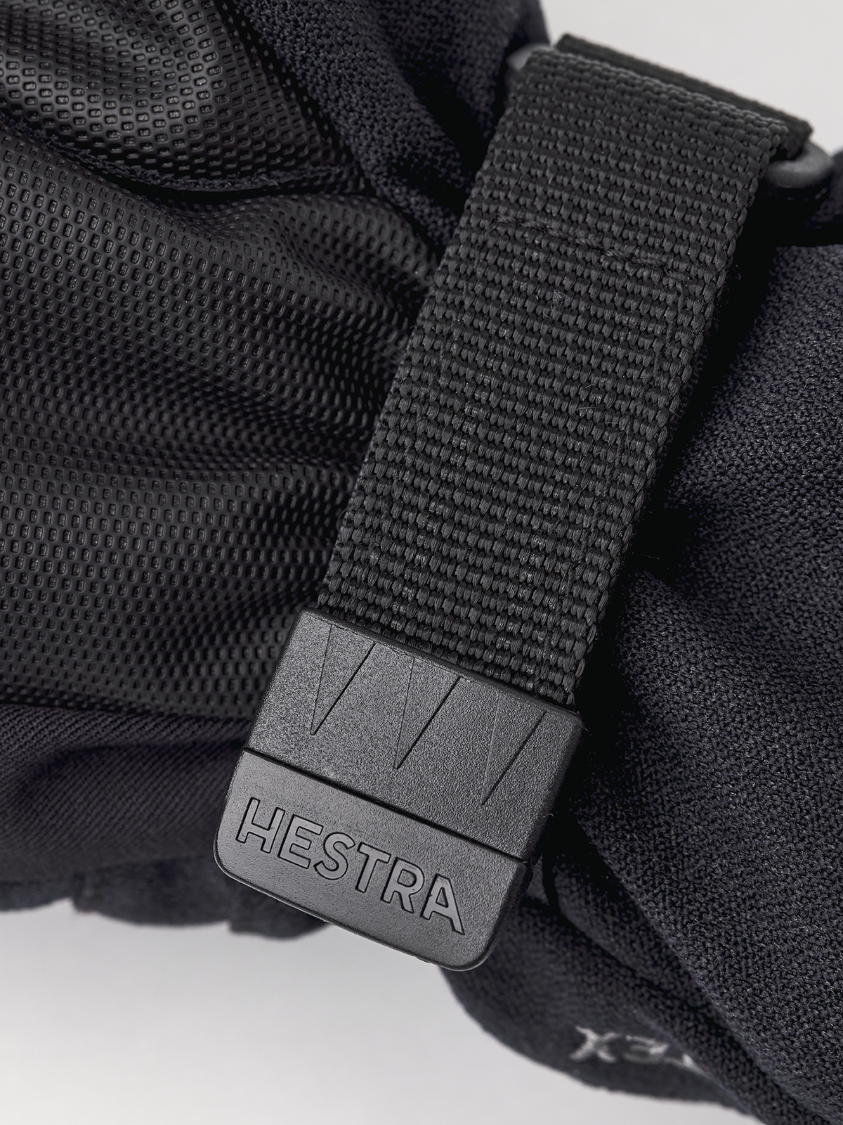 Hestra junior mitt close-up: gray buckle with Hestra logo on strap