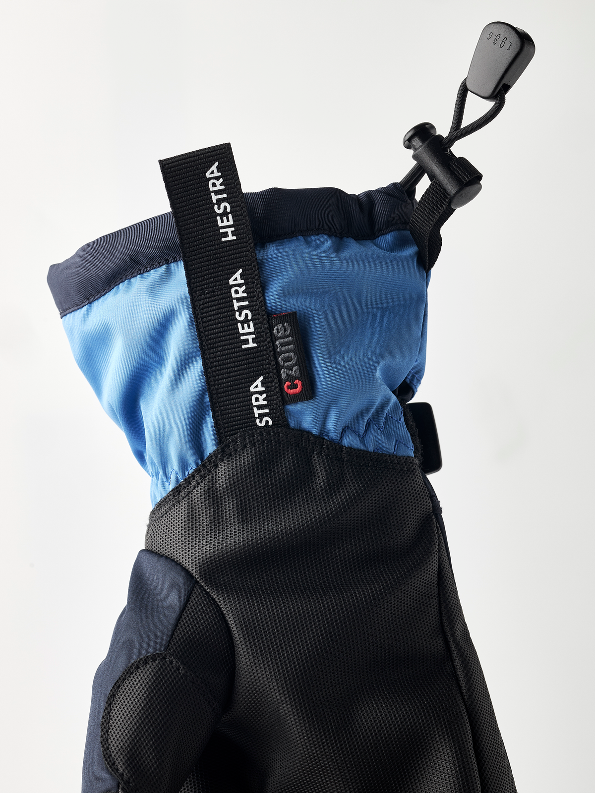 Kids blue and dark gloves with Hestra logo strap, textured knuckle area, pull tab
