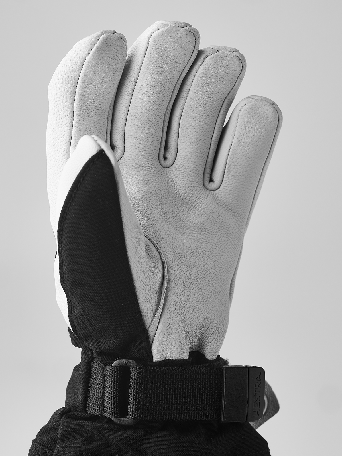 Hestra junior ski gloves with white leather back and black palm, plus wrist strap