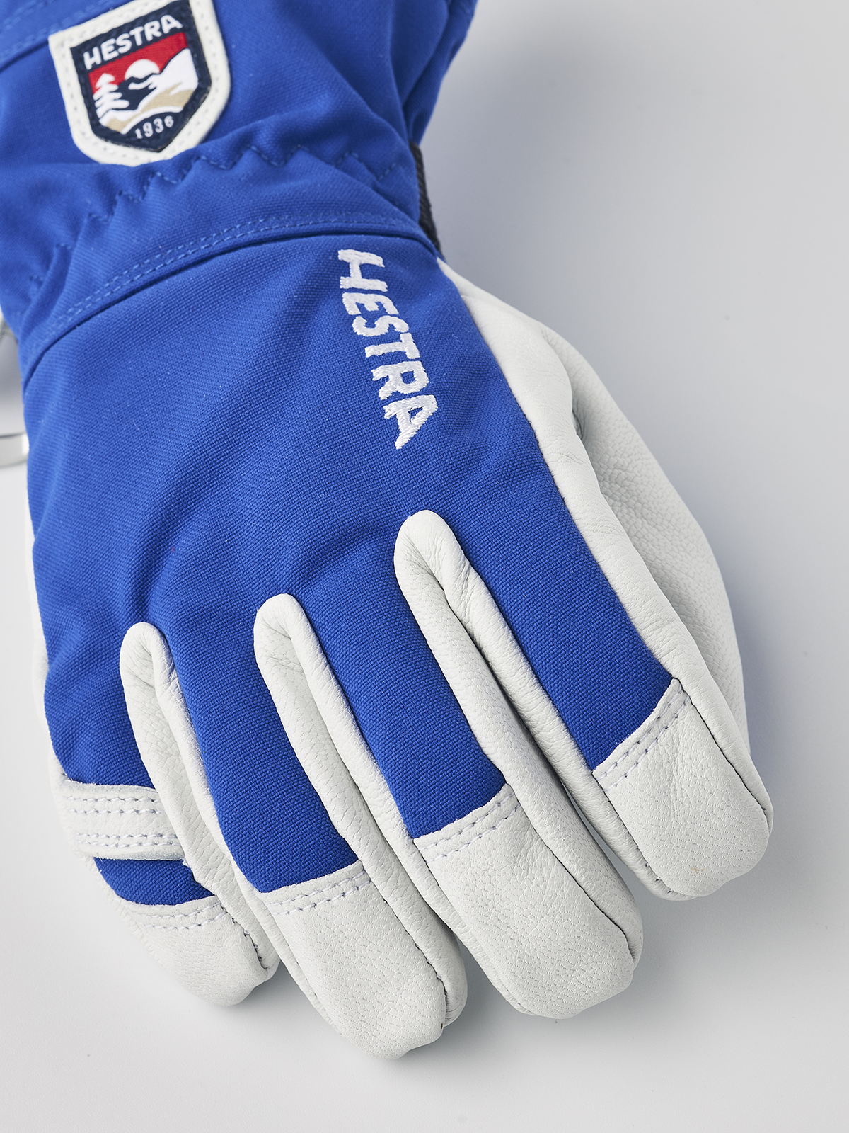Kids ski gloves in royal blue with white leather palms and stitched accents