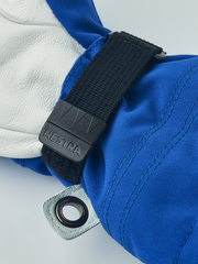 Kids ski gloves close-up: blue fabric cuff with black strap and grey fabric loop