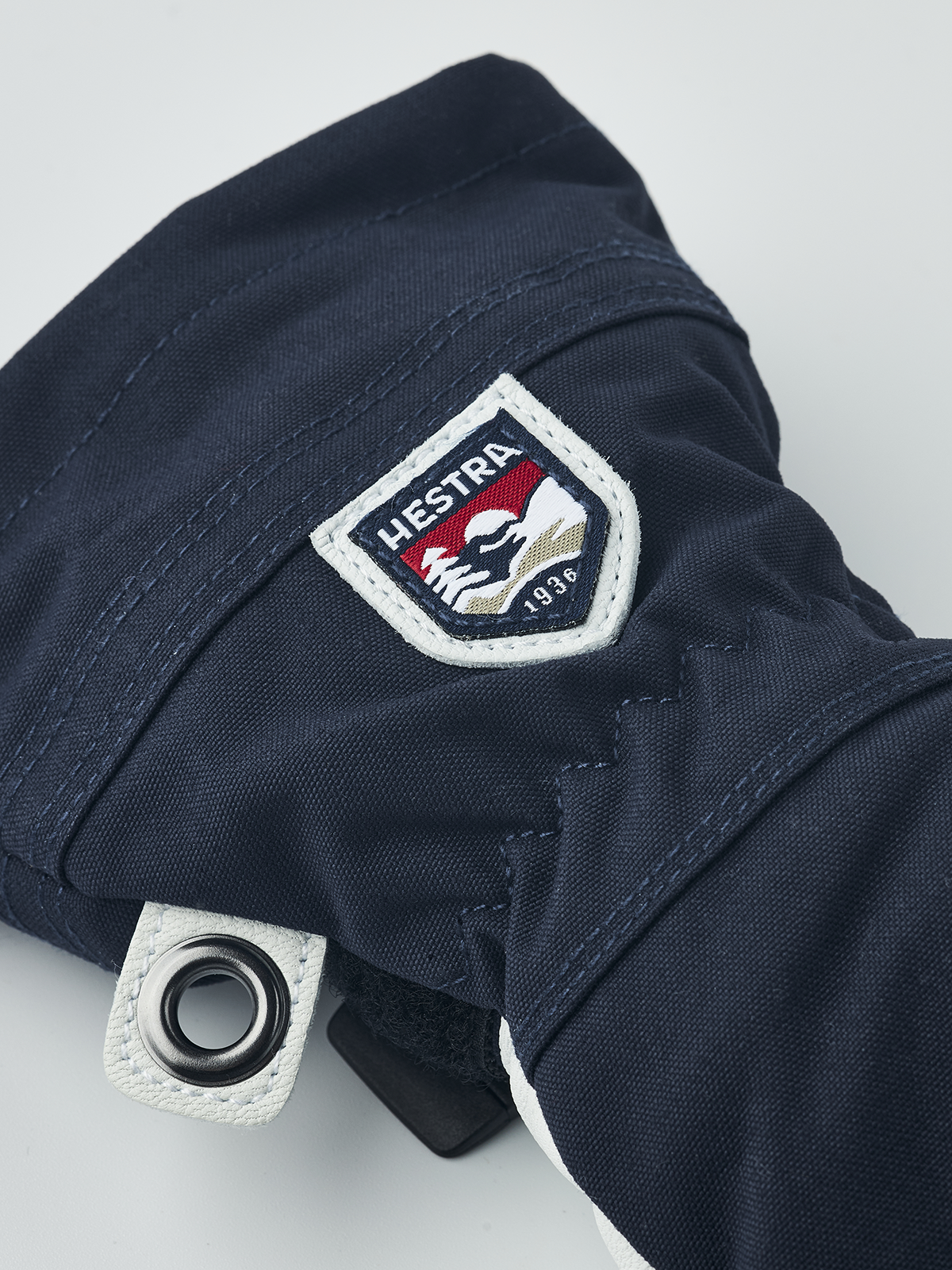 Hestra junior ski gloves in navy with Hestra logo patch and metal eyelet