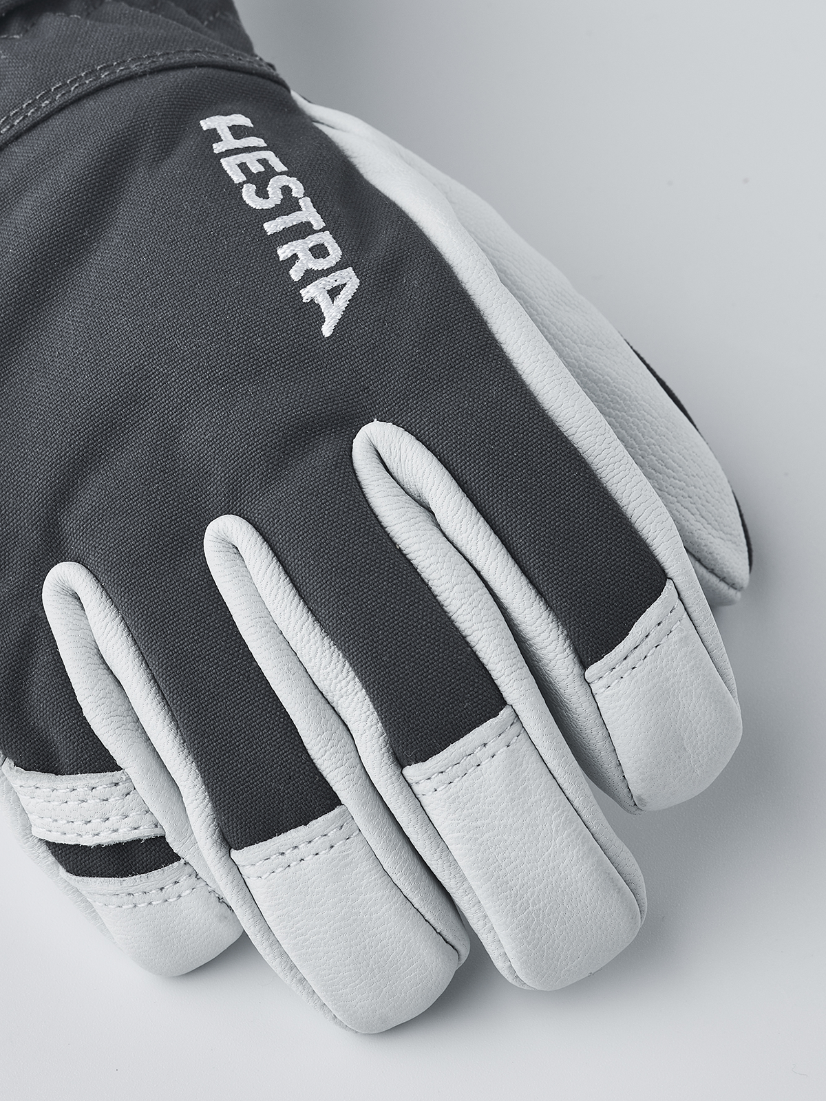 Kids dark grey and light grey ski gloves with Hestra lettering on back