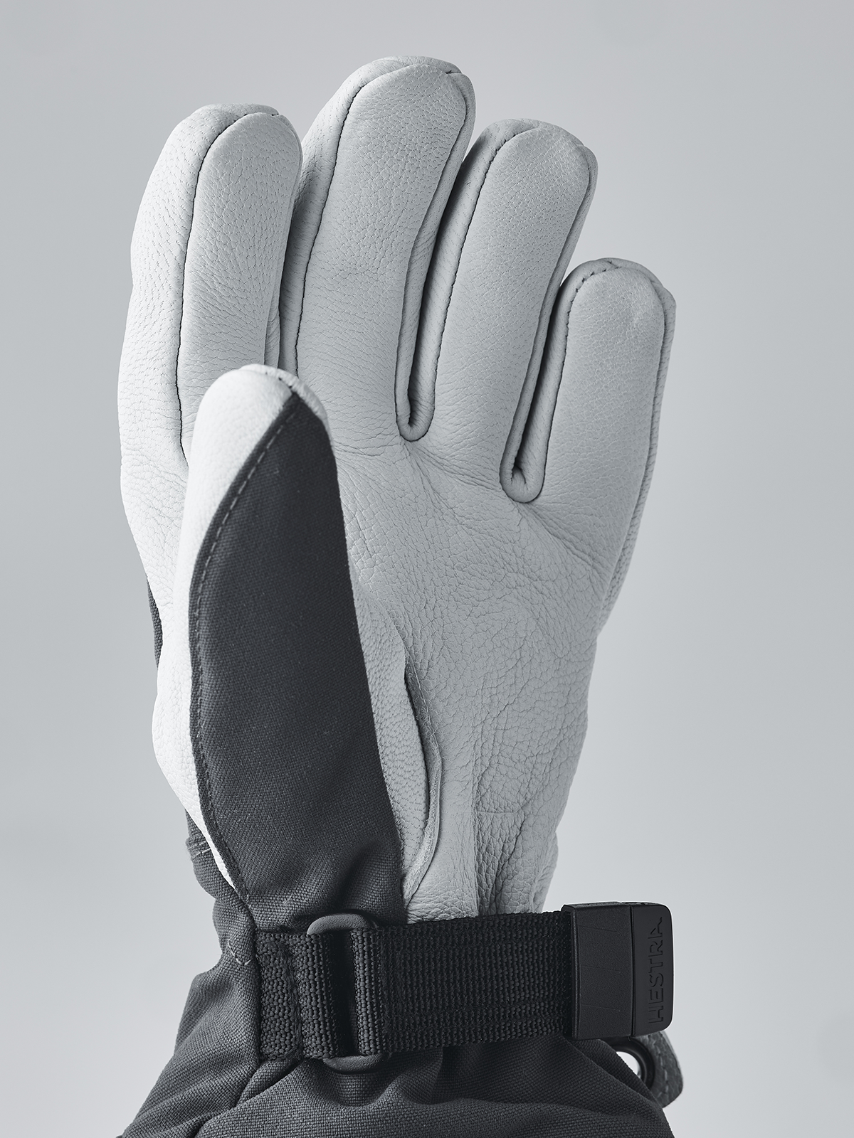 Hestra junior ski gloves in light gray with black palm panel and dark wrist strap