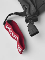 Gray ski junior glove with red HESTRA cuff lining and black cord lock