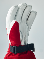White ski junior glove with red cuff panel and adjustable black wrist strap