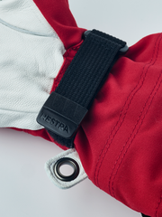 Hestra junior ski gloves in white and red with dark wrist strap and metal eyelet