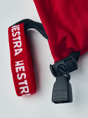 Red ski junior glove cuff loop with HESTRA label and black cord lock