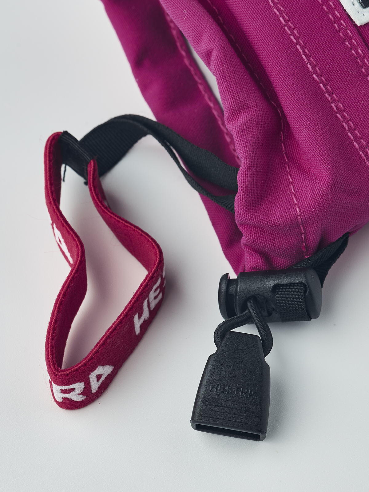 Kids ski gloves in fuchsia with white palms, black cuff strap, and red inner trim