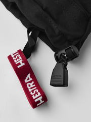 Junior ski glove close-up: red HESTRA strap with black plastic adjuster
