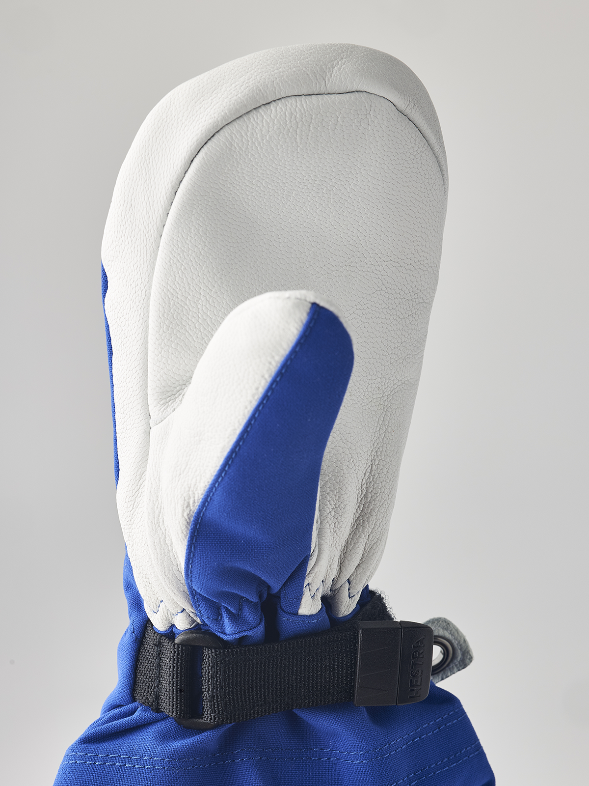 White and blue junior ski gloves with black wrist strap and leather palm
