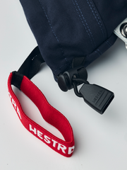 Red and black wrist strap on junior ski gloves with white Hestra logo