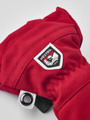 Kids ski mitten with red fabric, white-edged brand patch, and snap wrist closure