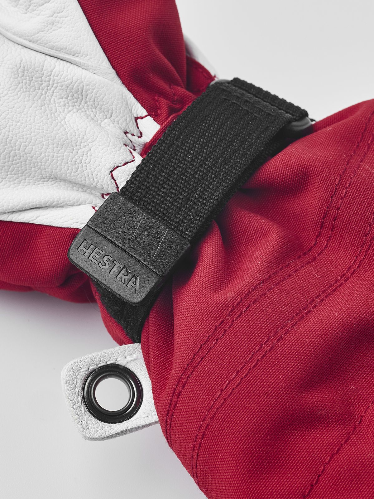 Kids ski mittens with white leather palm, red fabric back, and black hook strap