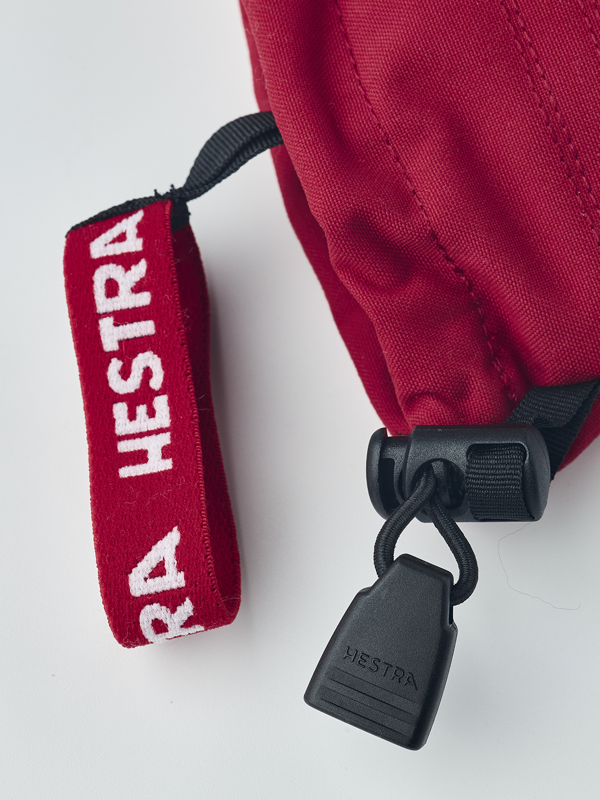 Kids Hestra ski mittens, red fabric with leather pull loop and brand tag