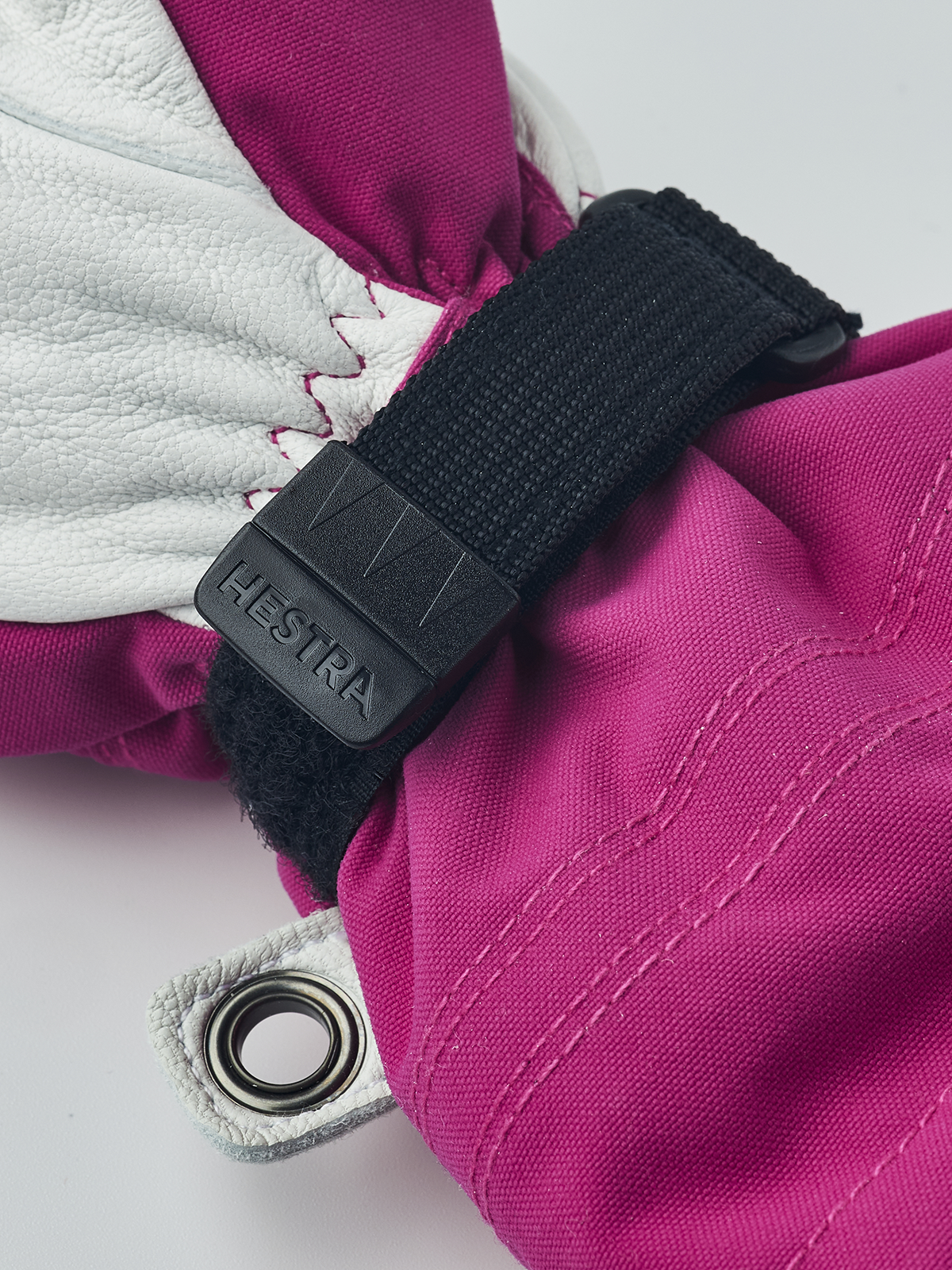 Kids ski mittens with magenta fabric, white leather palm, and black adjustable strap