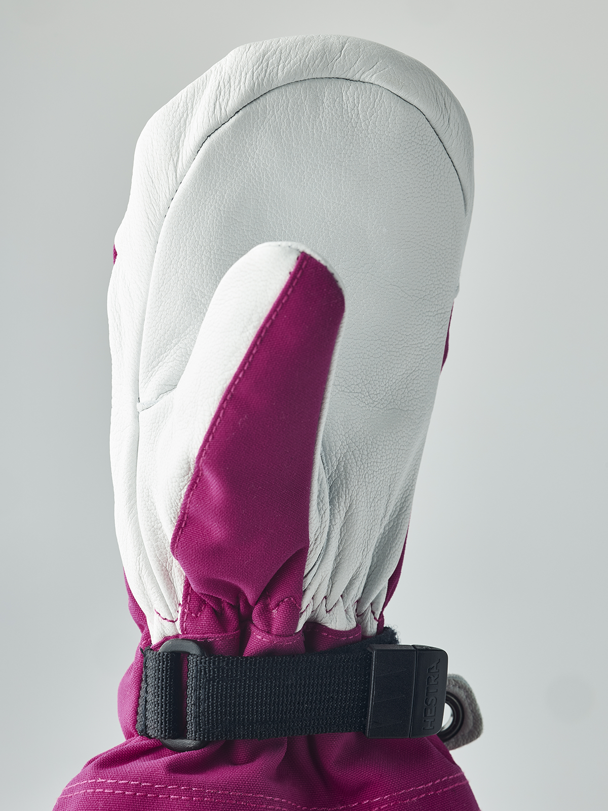 Kids ski mittens with white leather palm, bright magenta back, and black wrist strap