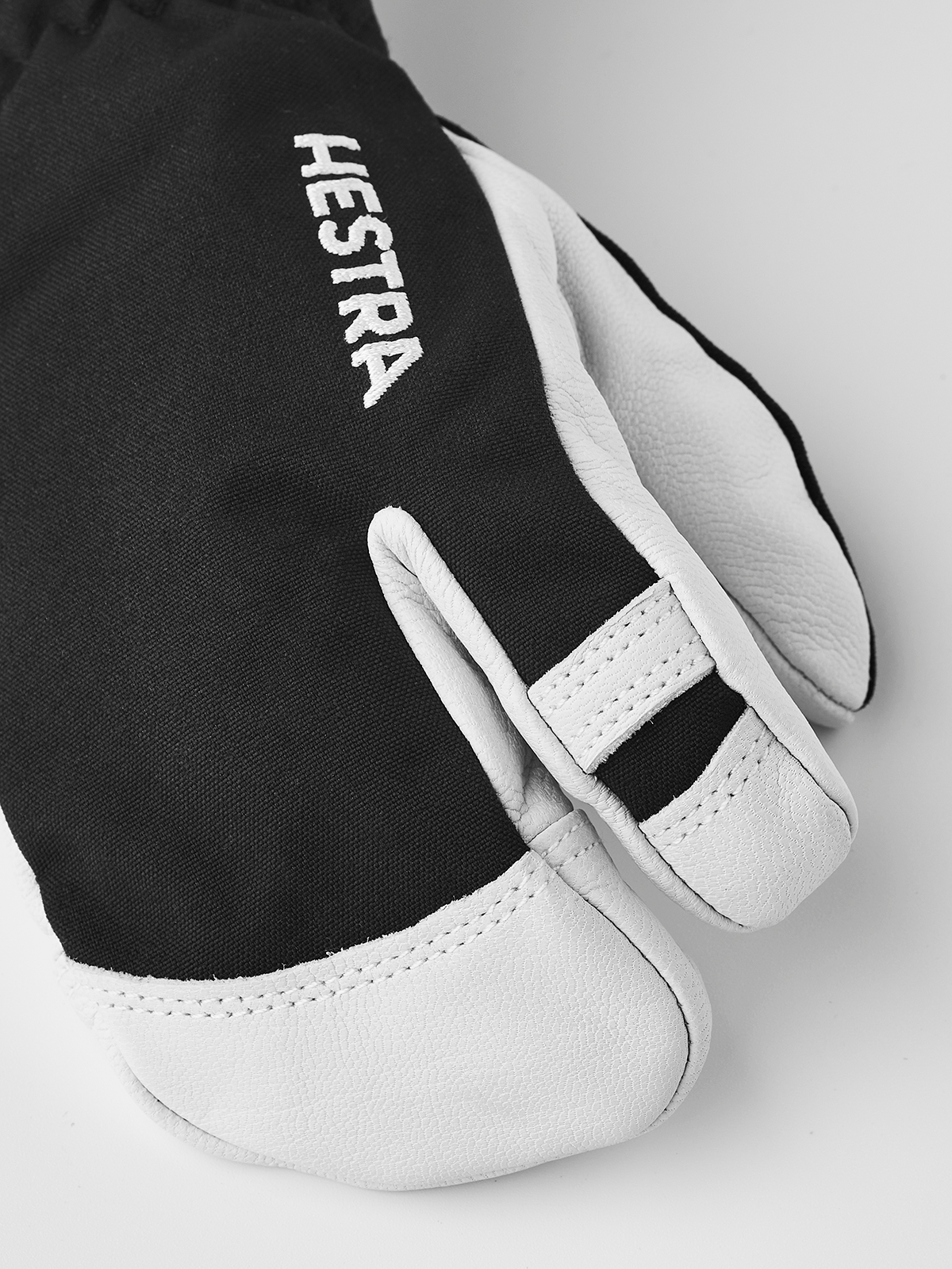 Junior ski gloves with black back panel and white palm, Hestra lettering