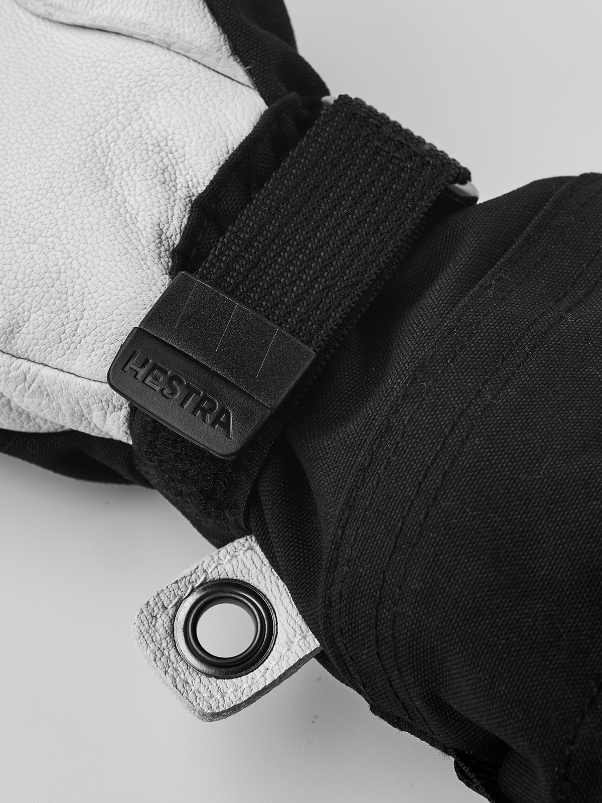 Hestra junior ski mitten close-up with black wrist strap and Hestra logo label