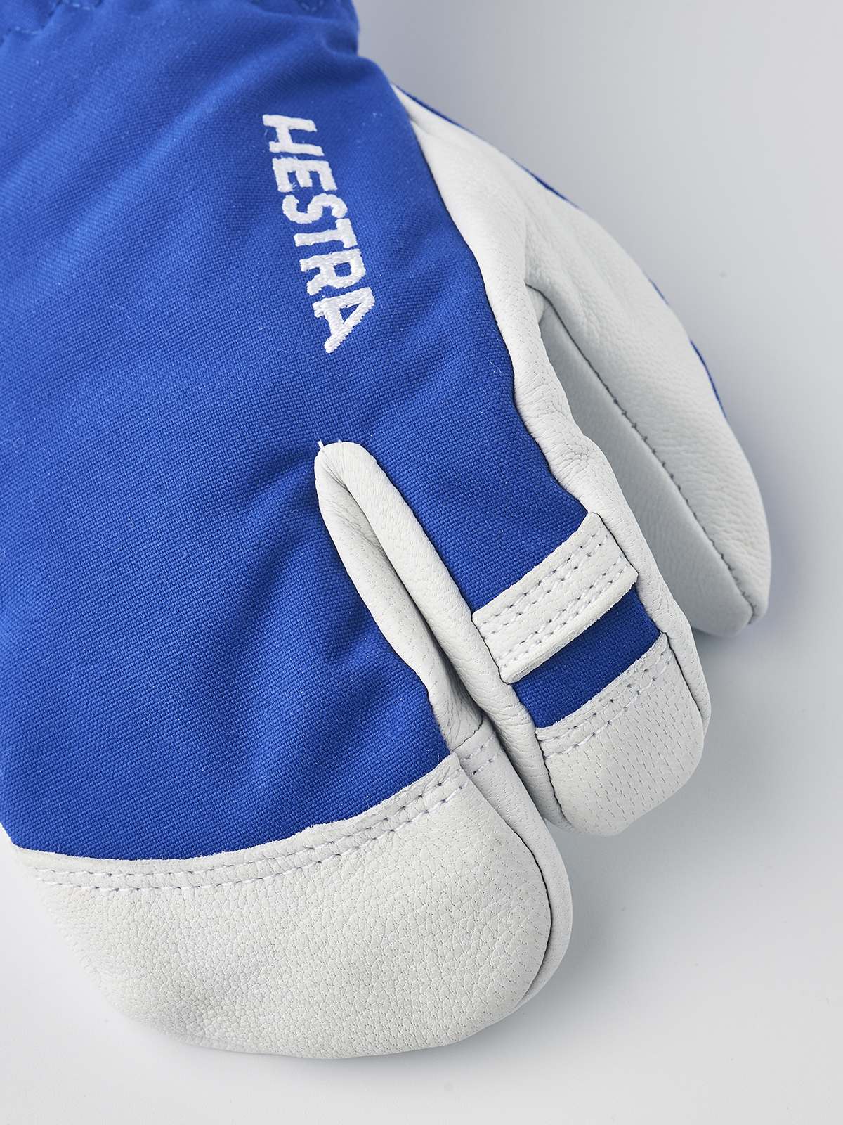 Hestra junior ski glove in blue and white with HE ST RA text on the cuff