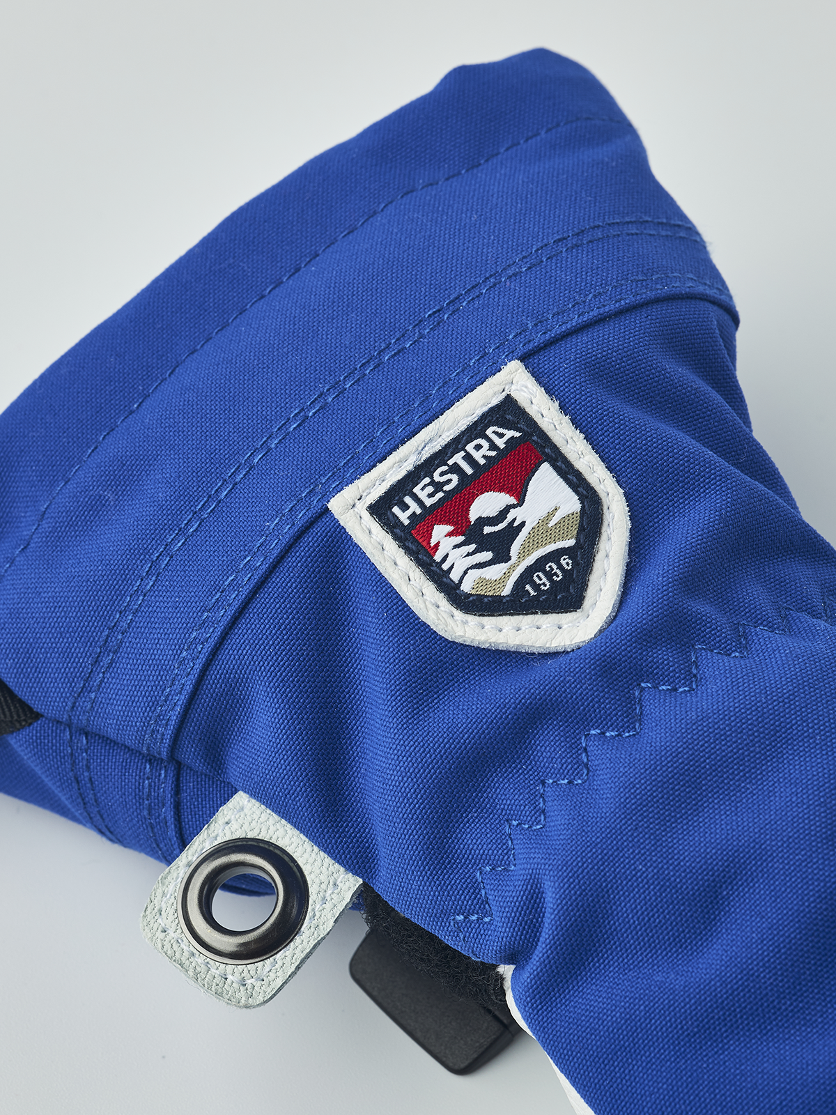 Junior ski gloves in royal blue with Hestra 1936 patch and metal grommet