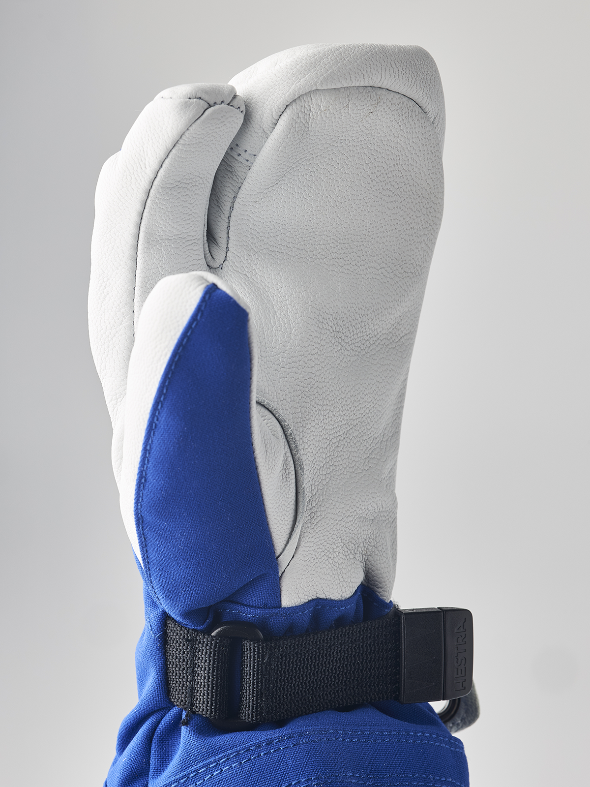 Hestra junior mitten in white with blue inner panel and black wrist strap