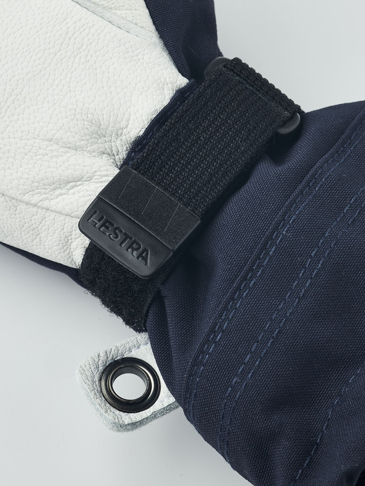 Junior ski gloves in navy blue with black wrist strap and metal grommet