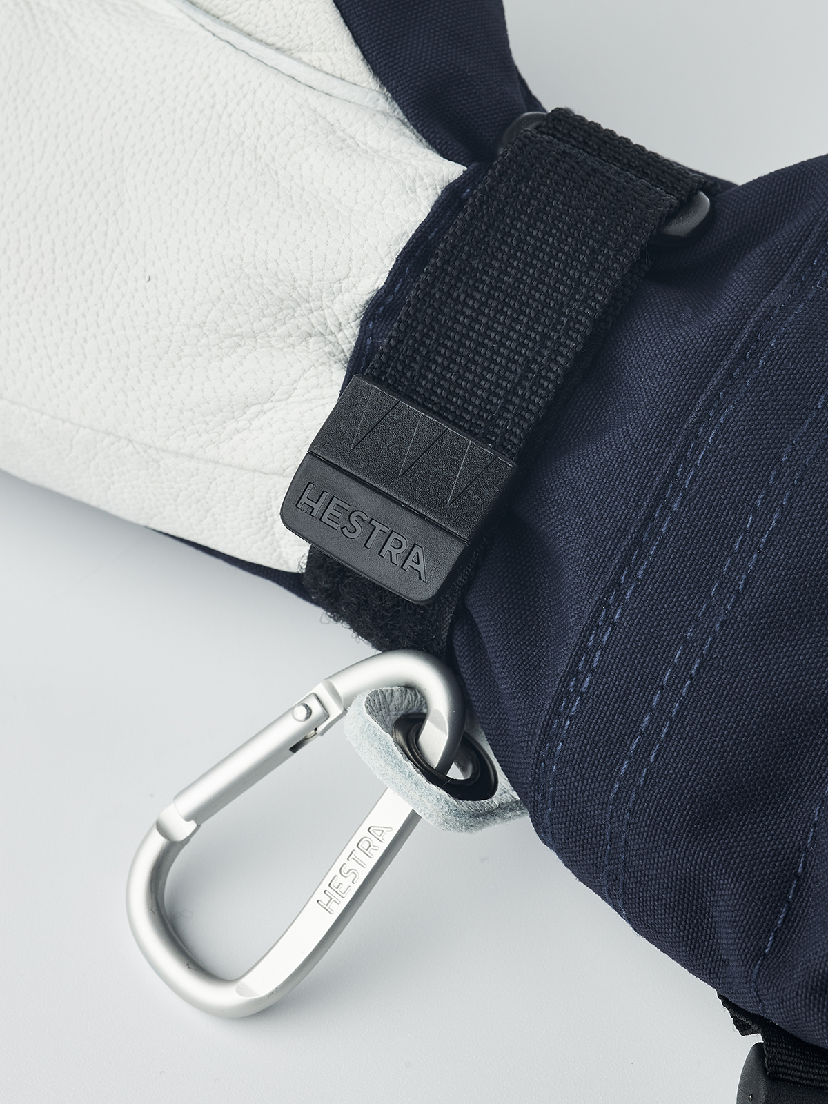Hestra junior ski gloves in navy with black wrist strap and carabiner key-ring clip