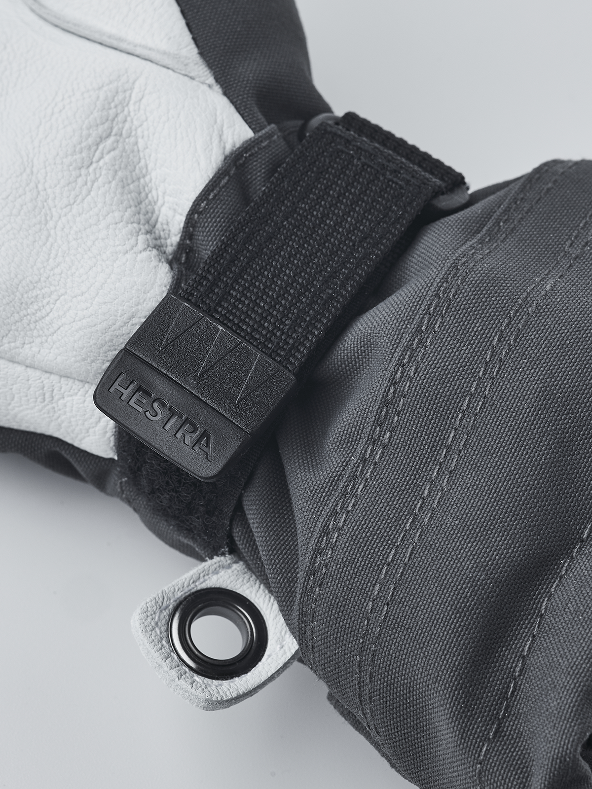 Junior ski gloves with black wrist strap, embossed Hestra patch and metal grommet