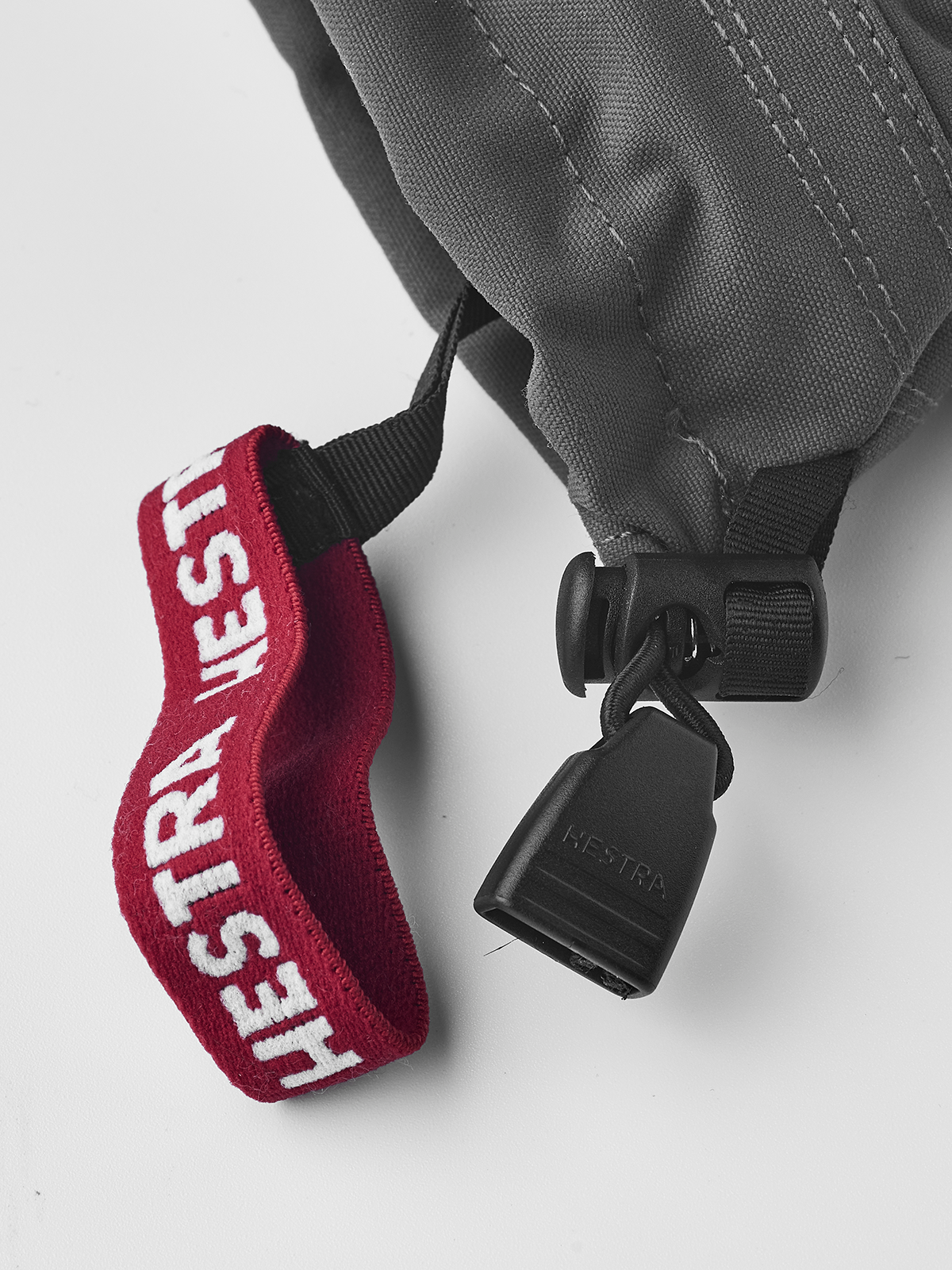 Junior ski mittens with red cuff, white Hestra logo, and black hanging clip