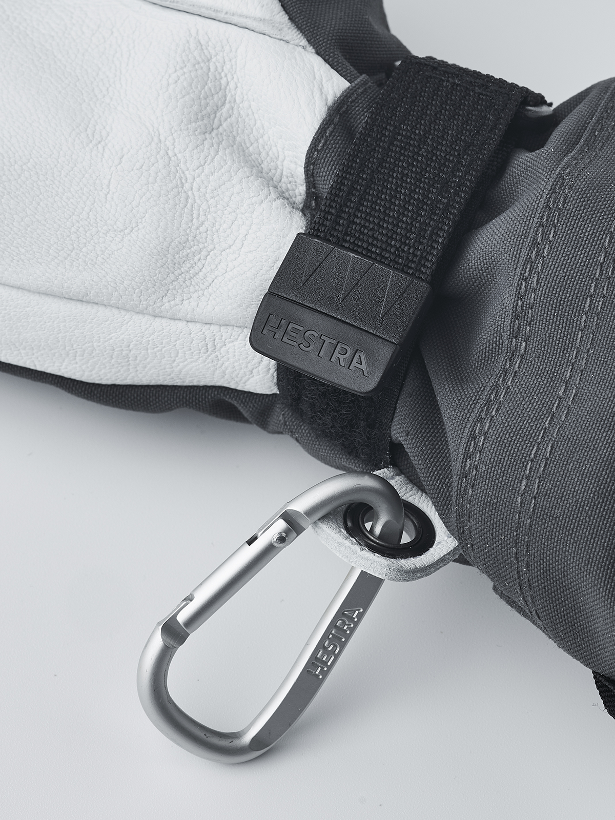 Hestra junior ski gloves in dark gray with black wrist strap and carabiner key-ring clip