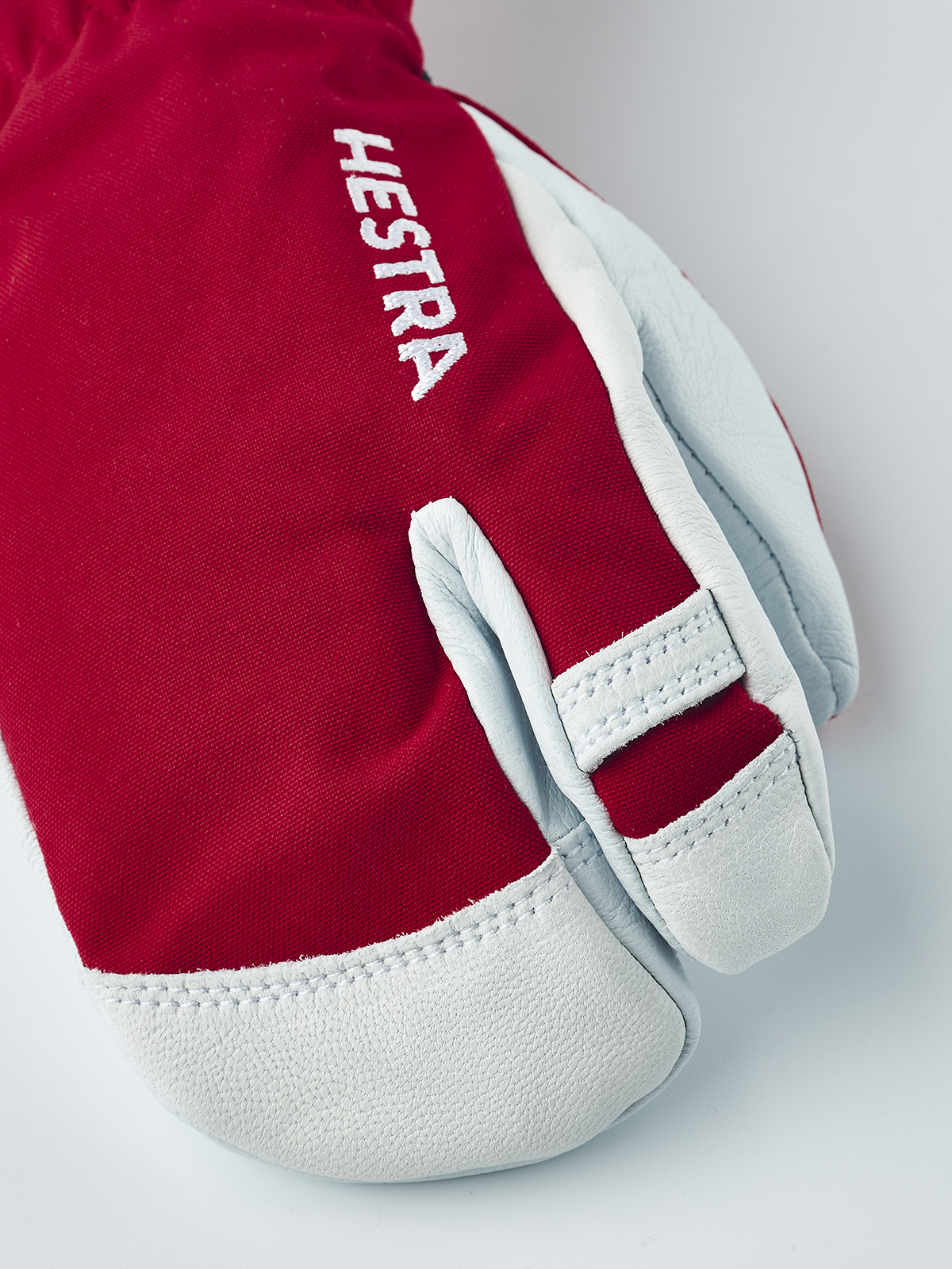 Junior ski glove in red with white leather palm and white “HESTRA” logo patch