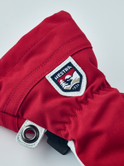 Red junior ski gloves with Hestra logo patch, leather palm and adjustable cuff