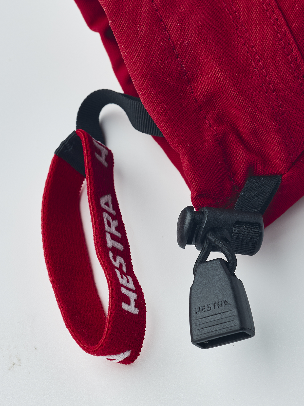 Hestra junior ski mittens in red with black lace loop and hanging strap detail