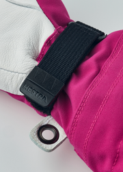 Hestra junior ski gloves in fuchsia with black wrist strap and metal eyelet ring