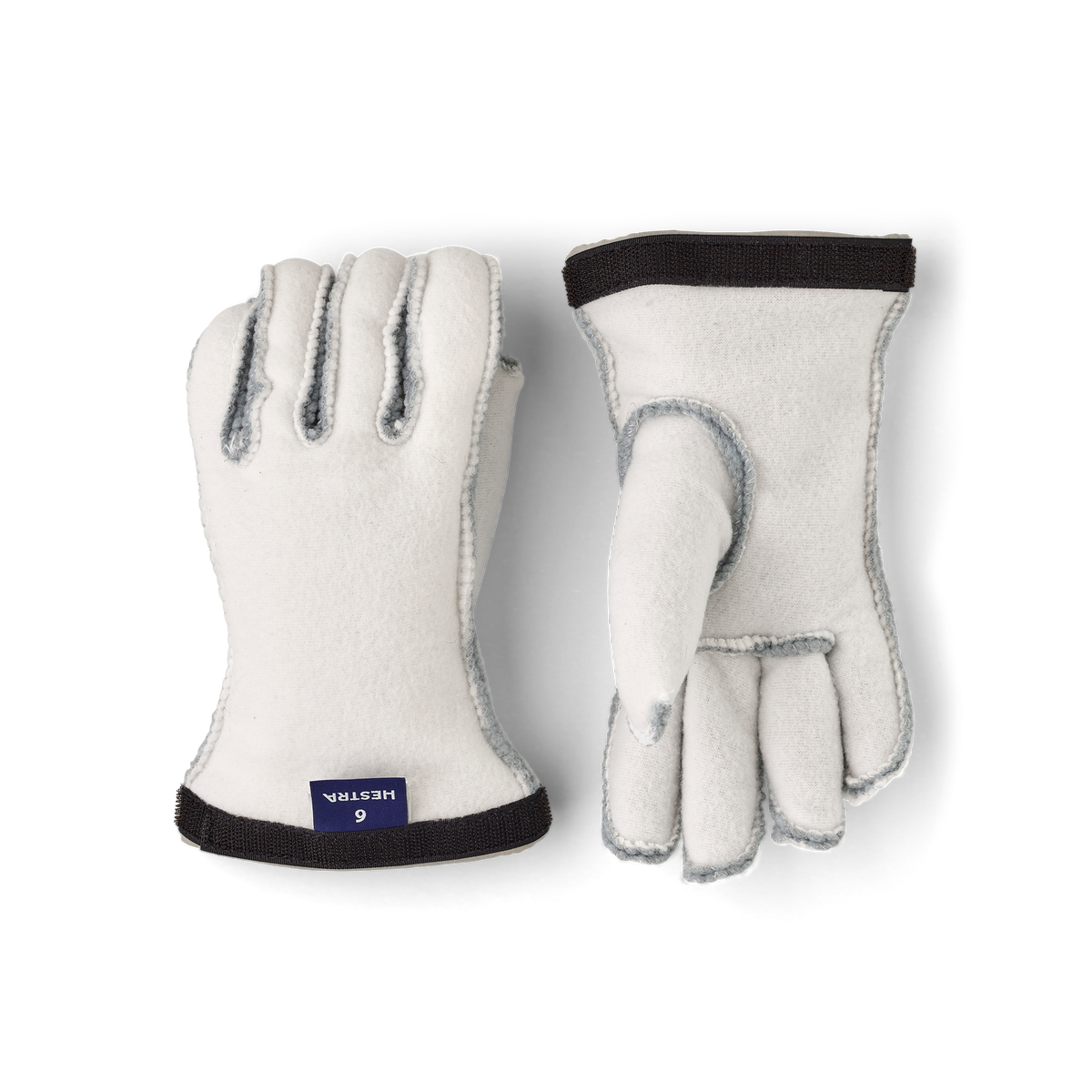Hestra kids' ski glove liners in off-white fleece with dark cuff and light-blue stitching