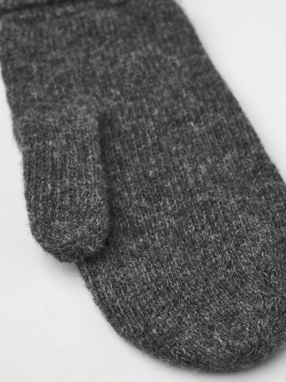 Dark grey knit mitten liner with ribbed cuff, close-up.