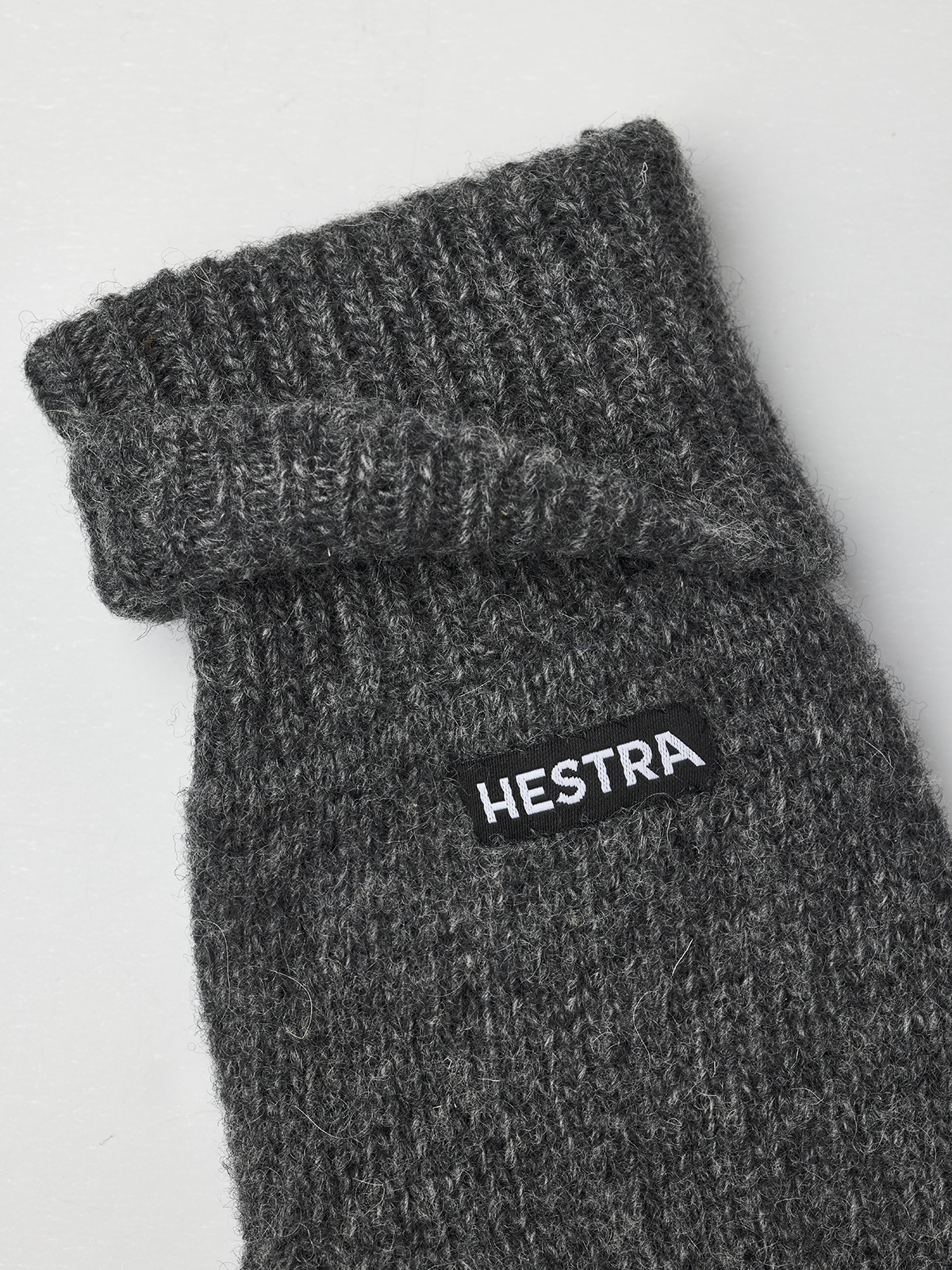 Grey knit mitten liner with ribbed cuff and HESTRA logo patch.
