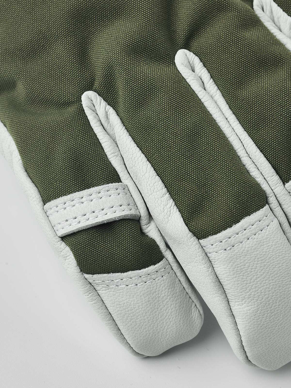 Olive green ski gloves with light gray leather palms and stitched finger panels