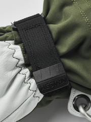Olive gloves with black wrist strap and pull tab on white leather panel
